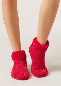 Pantofole rosse in maglia con polsini in pelliccia sintetica, caratterizzate da una texture morbida e un design aderente, che coprono la caviglia con motivi decorativi di cucitura.