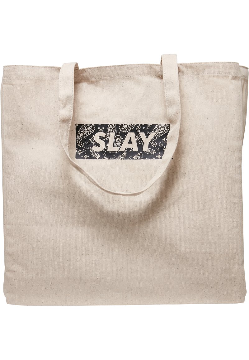 Canvas-Tragetasche in natürlichem Beige mit einem schwarzen rechteckigen Aufnäher, der den weißen Text "SLAY" und einen Paisleymuster-Hintergrund zeigt.