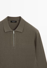 Langærmet olivengrøn strikket polo-shirt med krave og en halv lynlås i front.