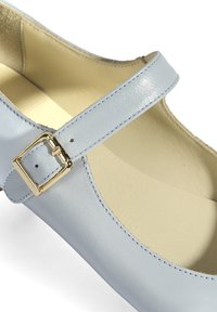 Helles blaues Leder-Schuh mit glatter Oberfläche, ausgestattet mit einem goldenen Schnallenriemen, runder Zehenpartie und beiger Innenauskleidung.