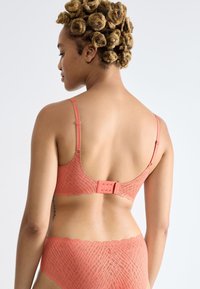 Reggiseno con motivo corallo, finitura in tessuto liscio, spalline regolabili e chiusura a gancio; presenta un design con bordo scallop.