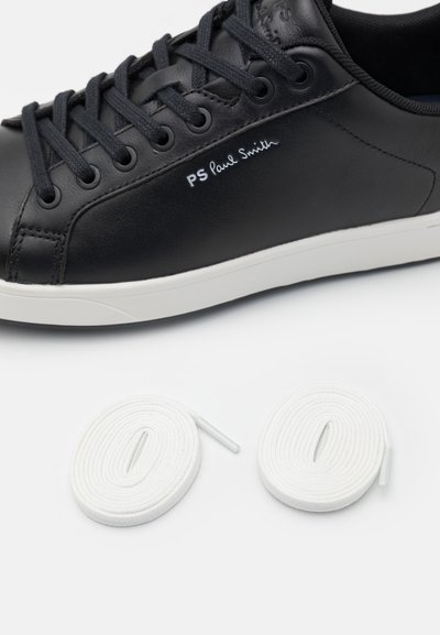 Black leather sneaker with white rubber sole; features rounded toe, laces, and PS Paul Smith logo. Two white shoelaces included.