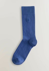 Calza blu a metà polpaccio con risvolto a coste e piccolo logo quadrato ricamato con la lettera N sulla gamba.
