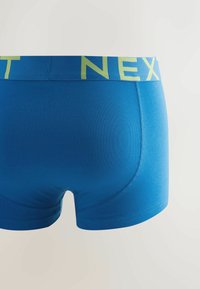 Modré bavlněné boxerky s žlutým páskem s logem "NEXT". Hladká textura a přiléhavý střih s minimem švů.