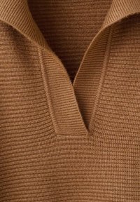 Close-up van een bruine gebreide trui met een geprofileerd geribbeld patroon en een V-vormige halslijn.