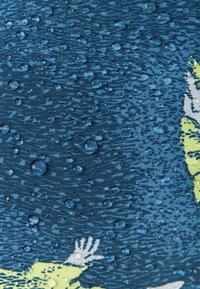 Il tessuto resistente all'acqua presenta uno sfondo blu con motivi testurizzati e gocce d'acqua prominenti di varie dimensioni sulla superficie.