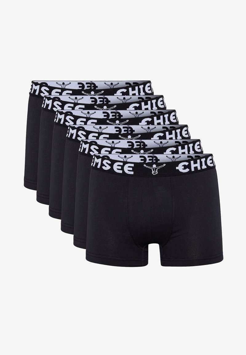 Schwarze Baumwollboxershorts, die in einer Reihe präsentiert werden, mit einem grauen Bund und einem Muster aus schwarzem Text und Logo. Sechs Paar sind sichtbar.