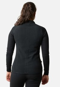 Sort langærmet top med en tætsiddende design, strækbart materiale og høj krave. Har ribbede ærmer og en glat, blød ryg.