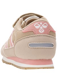 Beige och rosa barnsneakers med meshtyg, kardborreband och en vit bi-logotyp på hälfliken.