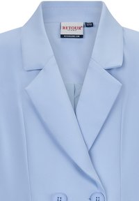 Blazer azzurro chiaro realizzato in tessuto liscio con colletto a garofano, bottoni doppi e un'etichetta con la scritta "RETOUR JEANS."