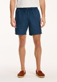 Navy blue swim shorts made from lightweight fabric, featuring an adjustable drawstring waist and a relaxed fit, ending just above the knee.
