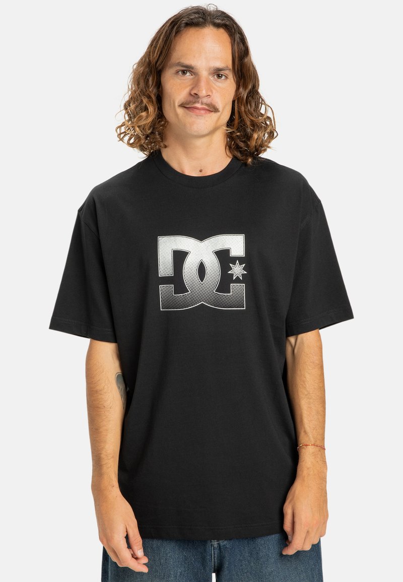 Black short-sleeve t-shirt featuring a large white DC logo on the front. Soft cotton fabric, relaxed fit, and round neckline.