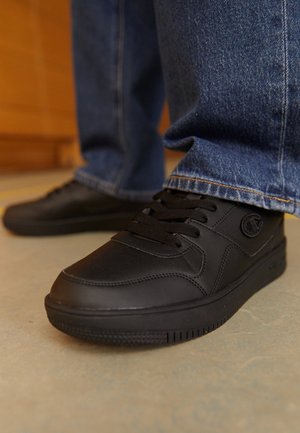 Schwarze Ledersneaker mit glatter Textur, minimalistischem Design, Schnürverschluss, Gummisohle und Logo-Detail an der Seite.