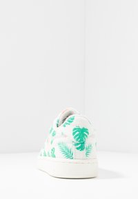 Sneaker in tela con una base bianca, coperta da motivi di foglie tropicali verdi. Caratterizzato da una finitura testurizzata e una suola in gomma.