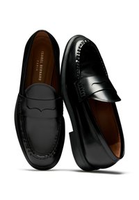 Schwarze Lederloafers mit einem eleganten Design, das ein dezentes Wellenmuster an der Vorderseite und ein kontrastierendes braunes Innenfutter aufweist.