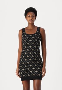 Black sleeveless dress with a square neckline, featuring a diamond pattern in cream, textured fabric, and a fitted silhouette.