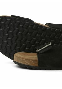Sandales noires en daim avec une semelle en caoutchouc texturé, un intercalaire en liège et une accent en boucle en métal. Présente un design à bout ouvert.