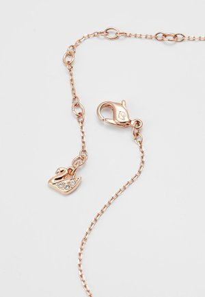 Collier chaîne en or rose avec un fermoir de type homard et un petit pendentif cygne orné de trois cristaux clairs.
