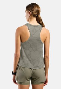 Light olive green tank top with a textured pattern, racerback design, and rounded hem. Paired with matching shorts, showcasing a relaxed fit.