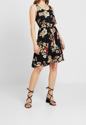 Schwarzes Blumenkleid mit tailliertem Schnitt und fließendem Rock. Es zeigt bunte Blumenmuster, breite Träger und einen runden Ausschnitt.