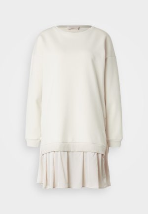 Felpa color crema con dettaglio gonna plissettata rosa chiaro, polsini a coste e zip laterali per un look stratificato. Texture liscia in tutto.