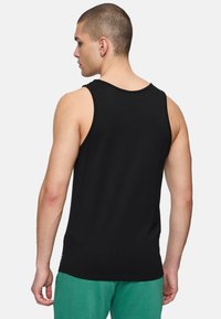 Top corto nero con scollatura rotonda, design senza maniche e taglio morbido. Realizzato in tessuto liscio con minimi dettagli di cucitura.