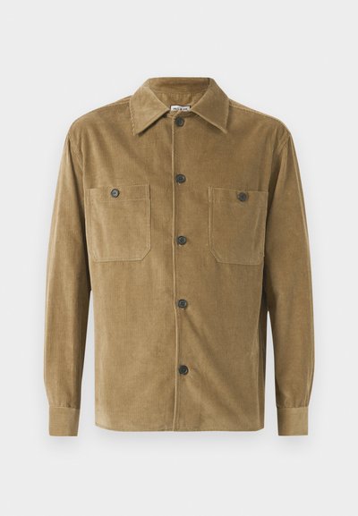 Brązowa koszula z korduroy z kołnierzykiem, dwoma kieszeniami na piersiach i czarnymi guzikami; cechuje się pionowym prążkowanym wzorem i długimi rękawami.