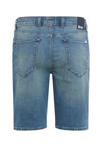 Rückansicht von mittelblauen Jeansshorts mit zwei Gesäßtaschen und einem schwarzen Brax-Label am Bund.