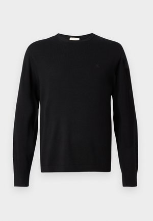 Schwarzer, langärmeliger Rundhals-Pullover mit dezentem "cK"-Logo auf der linken Brust, gerippte Bündchen und Saum, auf weißem Hintergrund präsentiert.