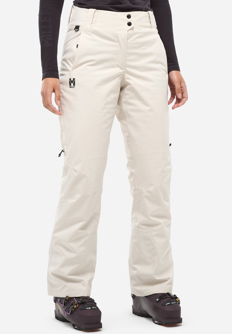 Pantalons de neige beiges avec une coque résistante à l'eau, deux poches latérales et des zips de ventilation, arborant un logo sur le devant et une coupe ample.