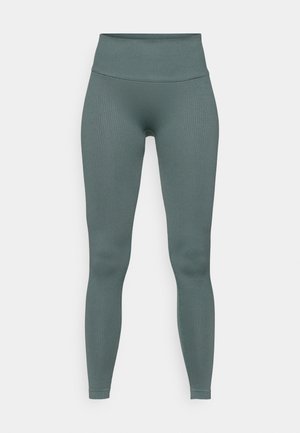Csíkos zöld leggings, magas derékkal, sima textúrával és testhezálló fazonnal, amely a bokáig ér.