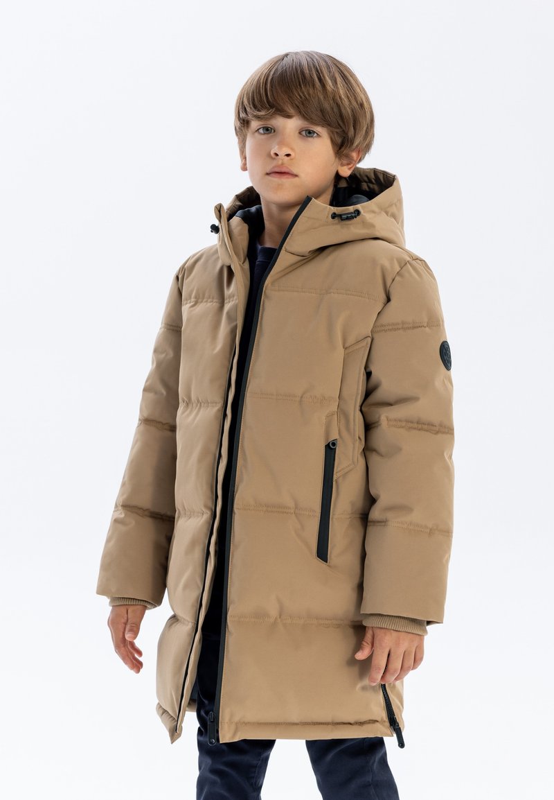 Beige vadderad parkas med huva, med svarta dragkedjor, strukturerad tyg och en något oversized design. Accenter inkluderar en logotyp-patch.
