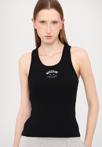 Melnā ribota bezdelīga ar kārtainu kaklu; priekšpusē ir balts izdrukāts teksts "MOSCHINO JEANS" un logo. Gluda tekstūra, pieguļoša dizaina.
