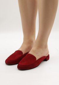 Rote Wildleder-Slipper mit abgerundetem Zehenbereich und kleinem Blockabsatz. Das Oberdesign weist eine glatte, breite Öffnung und klare Linien auf.