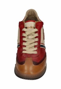 Red and beige leather sneaker with cream laces, brown accents, and a patterned tongue. Flat rubber sole and horizontal blue stripes.