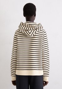 Gestreepte hoodie met een beige lichaam en donkerbruine horizontale strepen, met een trekkoordcapuchon en ribgebreide manchetten, van achteren weergegeven.