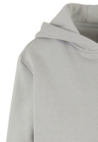 Sweat à capuche gris clair avec couture d'épaule visible et texture de tissu douce.
