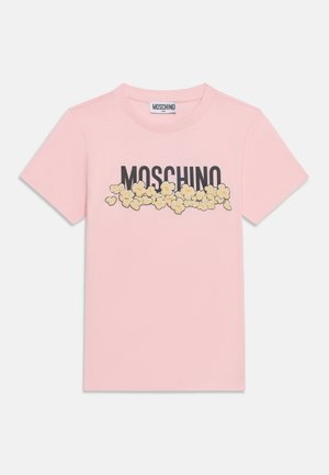 T-shirt rose à manches courtes avec le mot "MOSCHINO" en lettres noires partiellement recouvertes par des illustrations jaunes de pop-corn sur la poitrine.