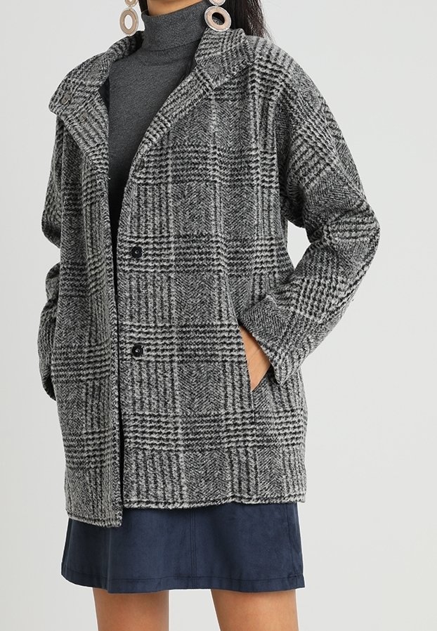 Grå och svart rutigt kappliknande plagg tillverkat av texturerad väv, med krage, två framfickor och knäppning.