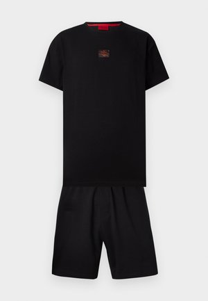 Czarna koszulka z krótkim rękawem z czerwoną naszywką z logo na piersi, zestawiona z pasującymi czarnymi szortami na jednolitym białym tle.