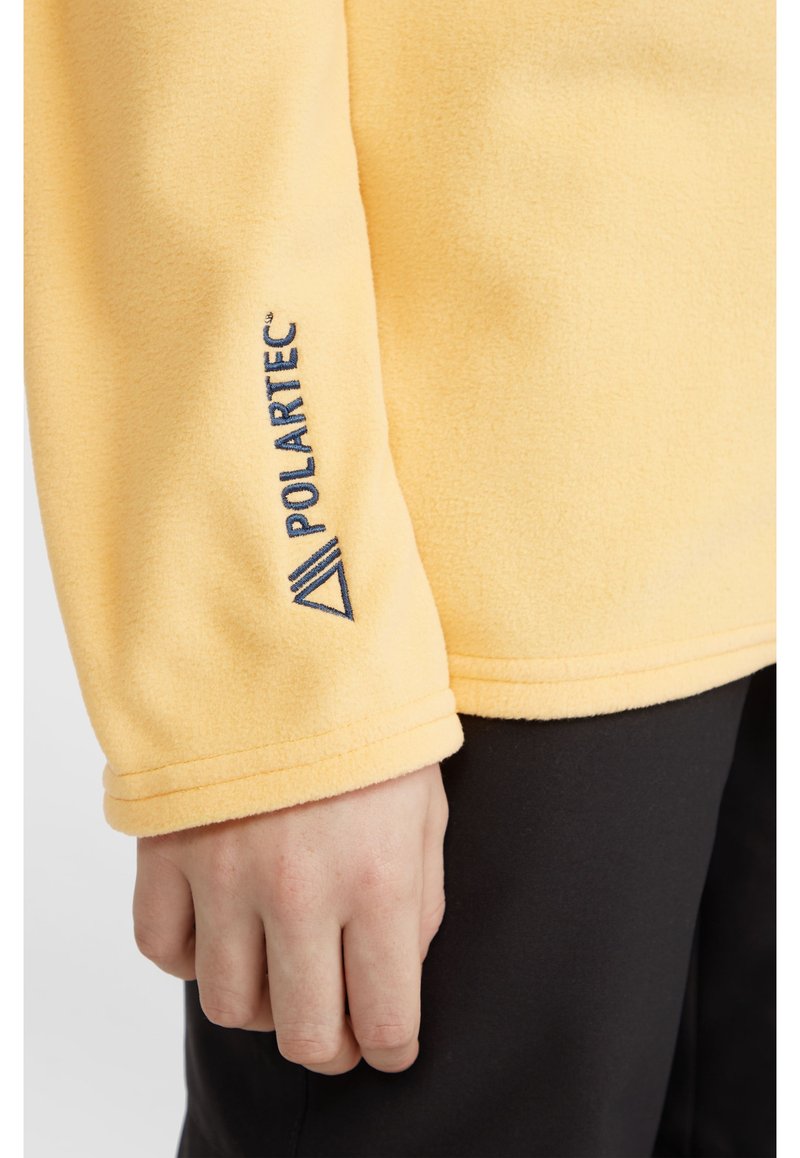 Gelber Fleece-Pullover mit weicher Textur, ausgestattet mit einem navy Polartec-Logo auf dem linken Ärmel. Einfaches Design und lässiger Schnitt.
