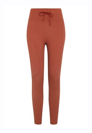 Rustfargede leggings laget av elastisk stoff, med høy livlinje, snor og sidepaneler for ekstra tekstur.