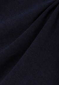 Marineblauwe stof, textuurgebreid, gladde oppervlakte met een lichte glans, gevouwen met een zachte val, die subtiele diepte en kleurvariaties toont.