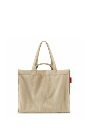 Beige corduroy tote bag met twee lange hengsels en een kleiner handvat, met een klein rood label aan de zijkant.