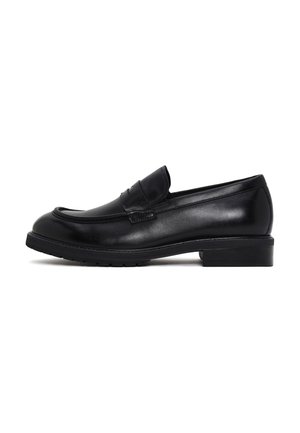 Zwarte leren penny loafer met lage hak en gestikte details, getoond in zijaanzicht op een witte achtergrond.