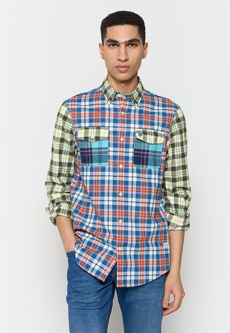 Karoshemd mit einer Mischung aus blauen, grünen, roten und weißen Karos. Lange Ärmel mit zwei Vordertaschen und Knopfverschluss. Aus Baumwolle.