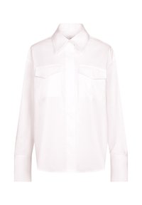 Chemise blanche à manches longues, boutonnée, avec col pointu et deux poches poitrine à rabats, présentée sur un fond uni.