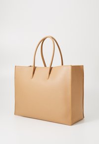 Sac fourre-tout en cuir tan avec une surface texturée, de forme rectangulaire et deux poignées arrondies. Design minimaliste, sans matériel ou accents visibles.