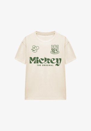 Beiges kurzärmeliges T-Shirt mit grünem "Mickey The Original" Text, einem Mickey-Mouse-Kopf mit Kappe und einem Fußballvereinswappen auf der Brust.