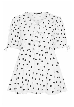 Witte blouse met korte mouwen, zwarte polkadots, drie strikjes aan de voorkant, opgeblazen mouwen en een uitlopende zoom.
